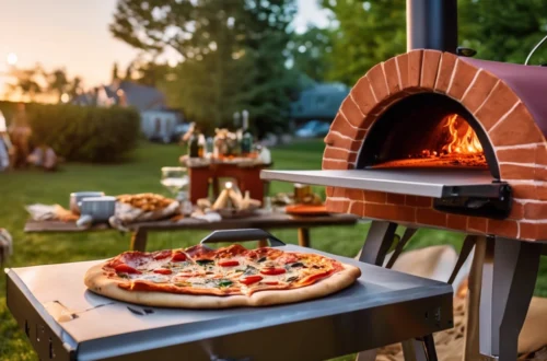 Outdoor wood-fired pizza oven baking a fresh pepperoni pizza on a sunny backyard patio, with a picnic table and food in the background.